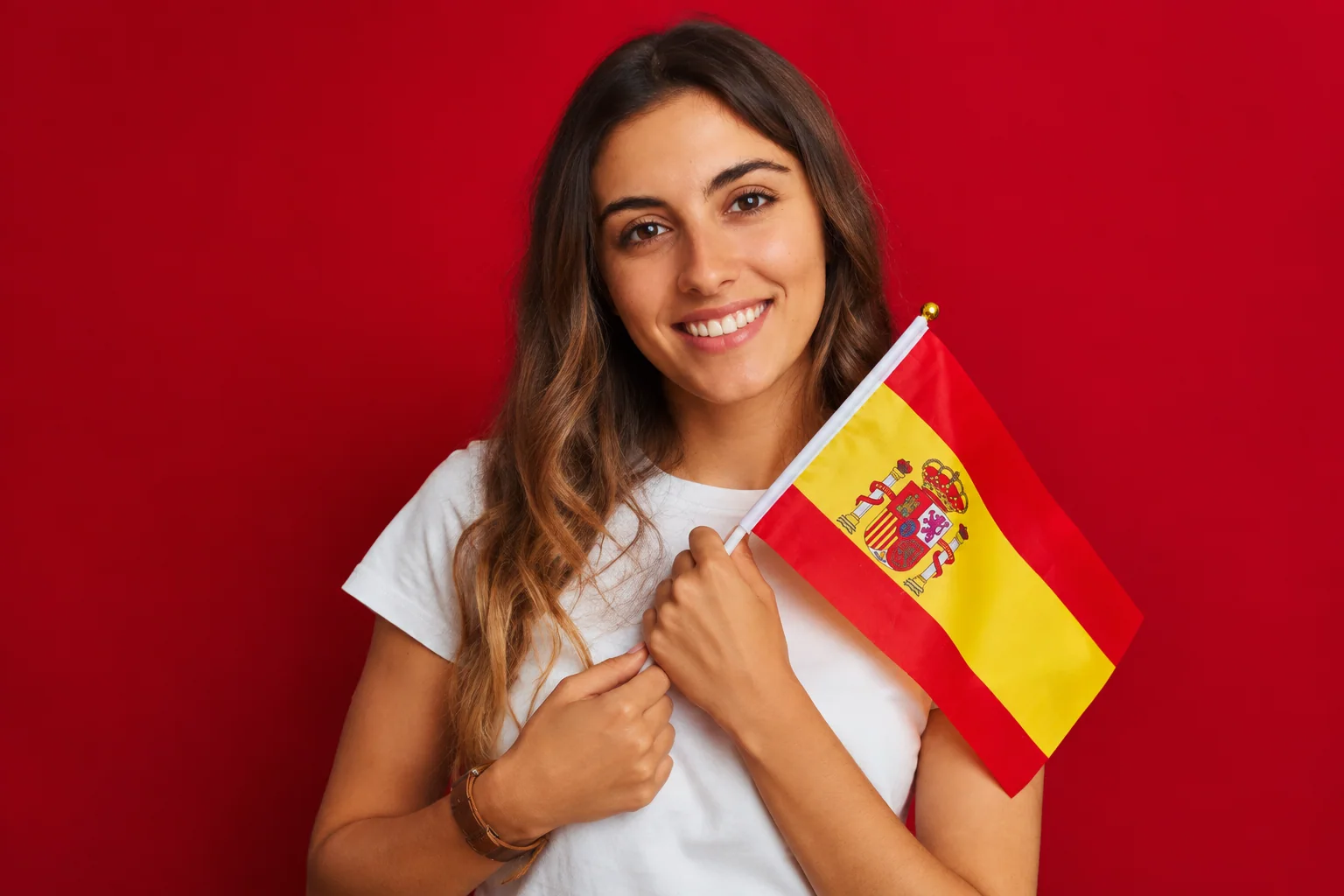 Jovem com uma bandeira da Espanha em um fundo vermelho.